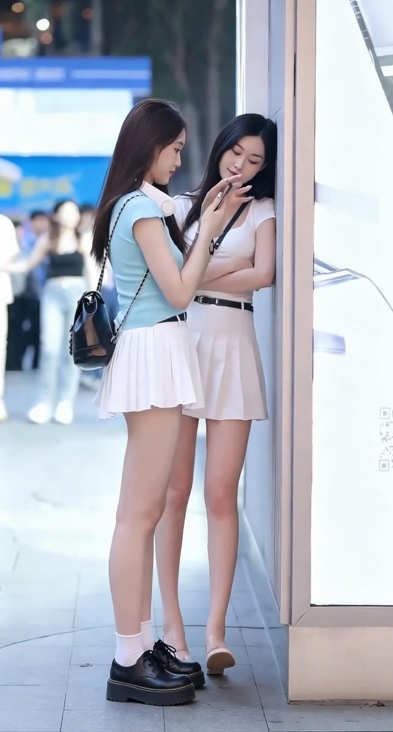 少女相伴漫步街头，满是鲜活青春气息，这便是生活最美好的模样。