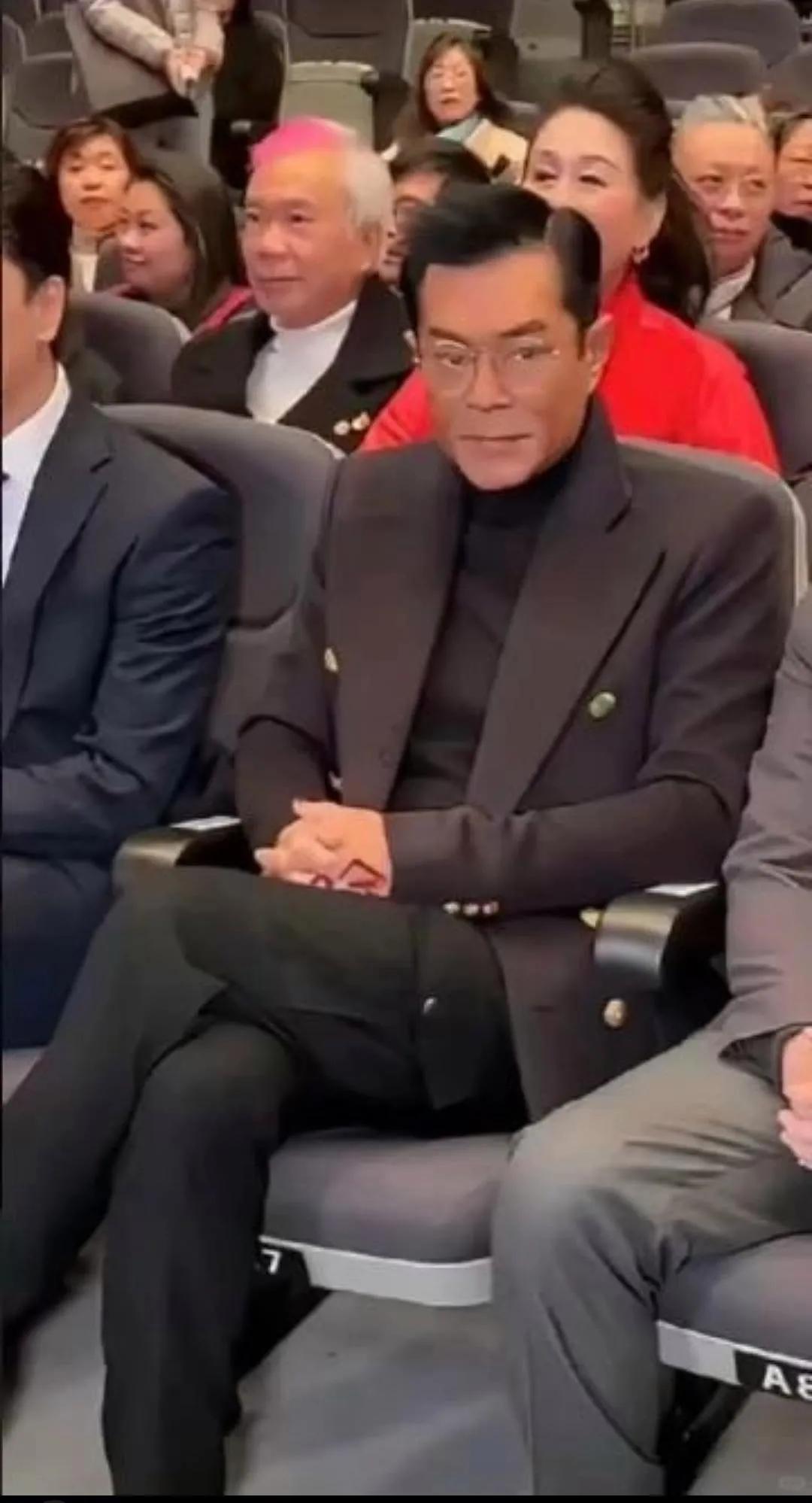 哇哦，画面中的古天乐西装革履，清瘦斯文，身形佝偻，脑袋又长又窄，面部肌肉松弛，脸