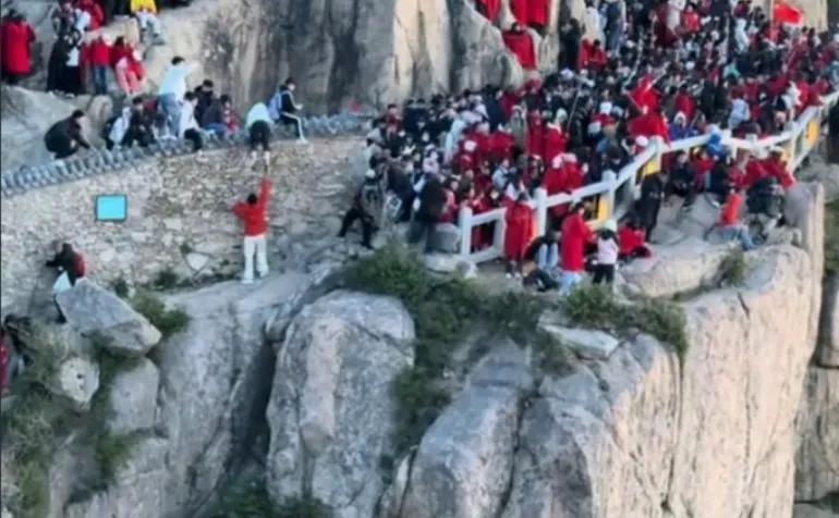 泰山翻墙超近道，同伴空手接没站稳双双摔下，幸好死死卡在崖缝里，最起码证明了男生很