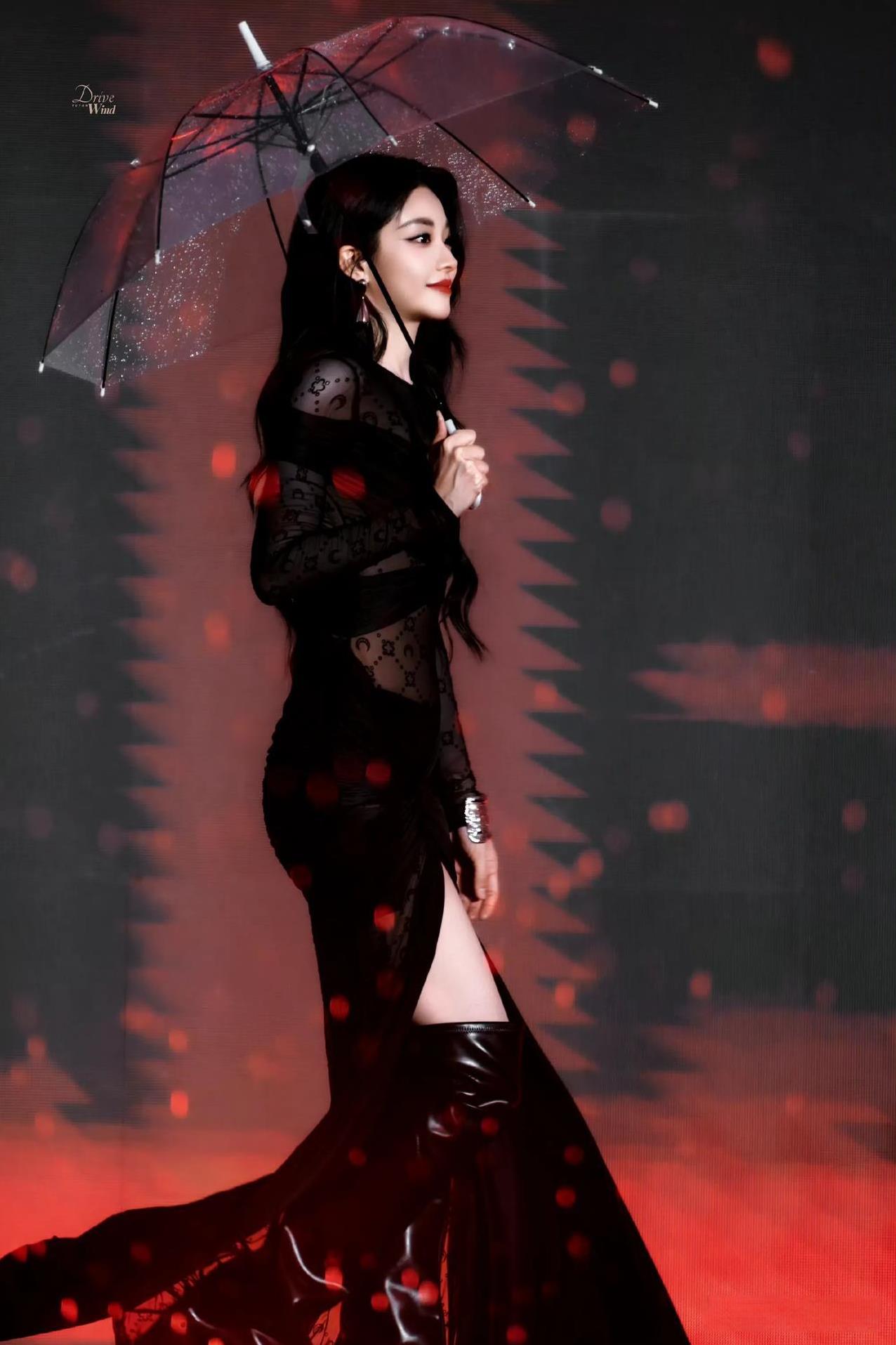 喻言撑伞登场，黑纱裙勾勒出凹凸曲线，开叉处大秀美腿。皮肤白到反光，红唇明艳，眼神