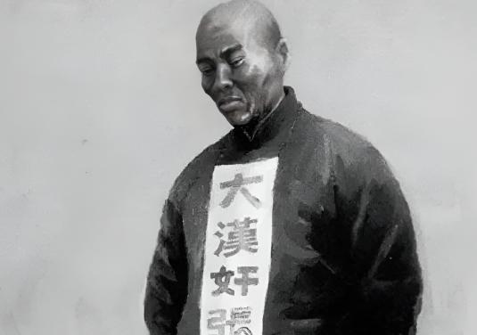 1951年的大连刑场，86岁的张本政戴着破毡帽，后衣领插着"反革命汉奸犯"的标牌