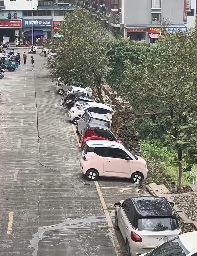 持续降雨导致泥土塌方，硬地面上停放着的汽车已岌岌可危，但没一个人敢去把车开走，因