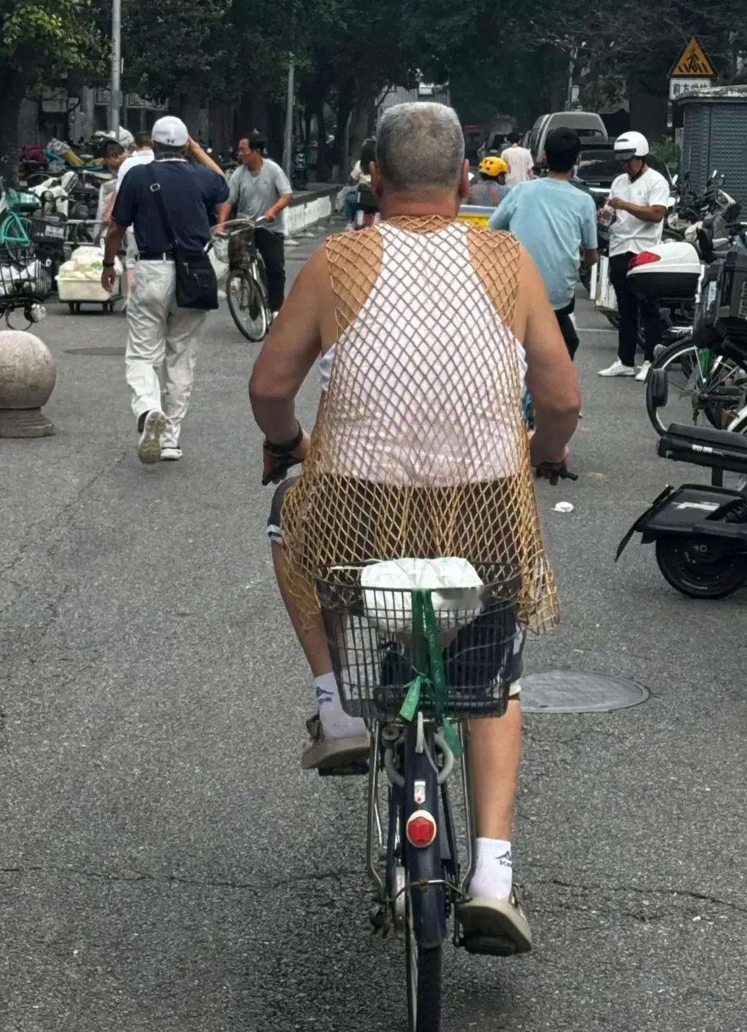 大爷这“渔网”穿搭太潮啦，骑车自带松弛感，把日子过成了街头时尚大片！