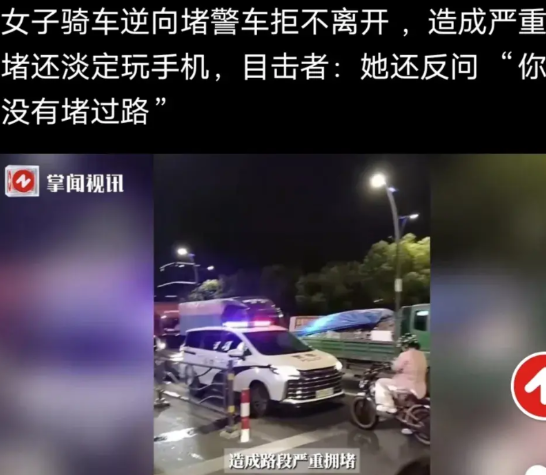女子骑车逆向堵警车拒不离开，造成严重拥堵还淡定玩手机，有目击者劝阻，被女子反问: