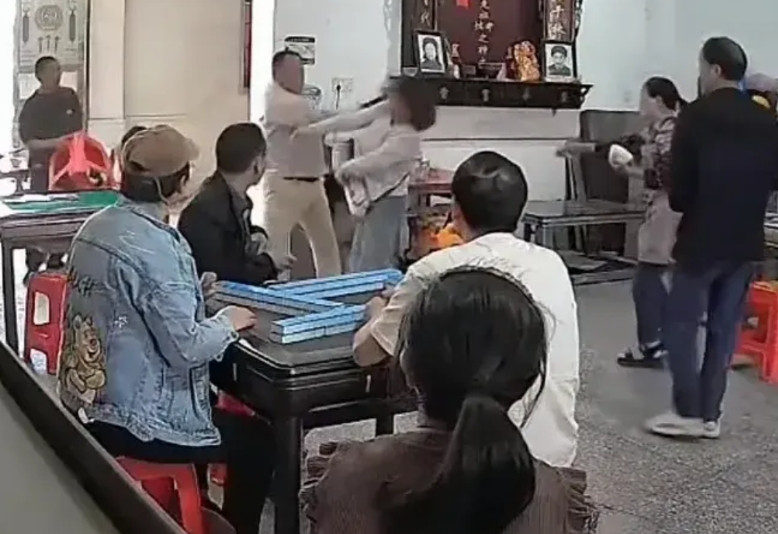 麻将馆里两桌人打麻将，一中年男人与一名中年妇女吵了起来，双方争执不休，公说公有