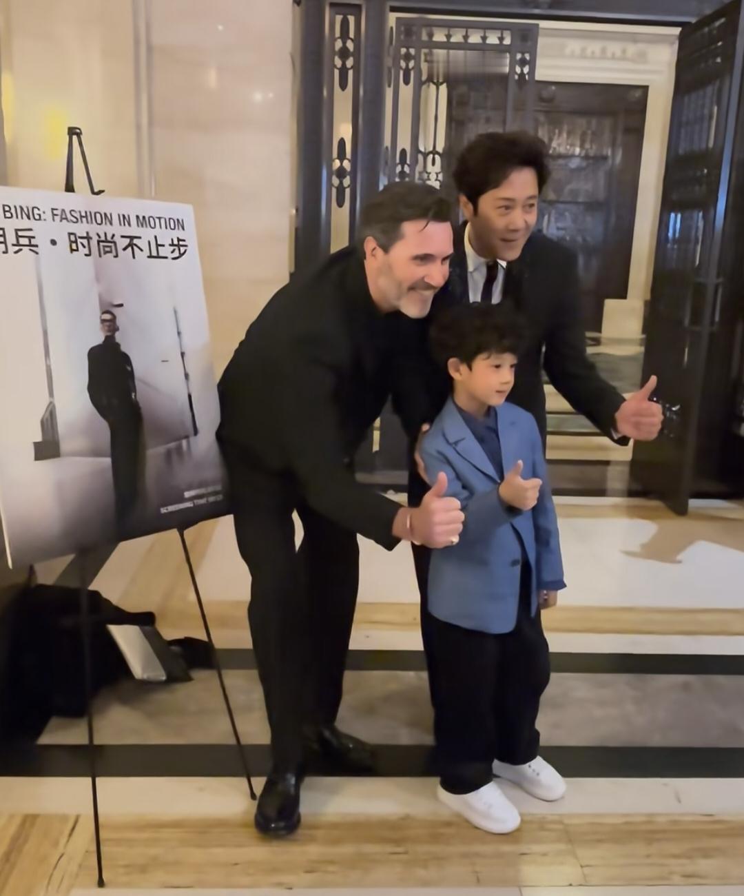57岁蔡国庆带着7岁小儿子庆宝参加伦敦时装周，父子俩都穿着西装，打扮绅士有型，好