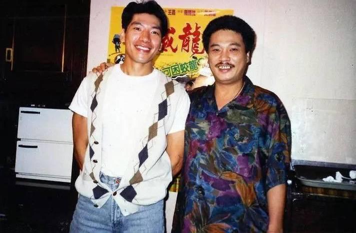 1991年7月，香港演员吴孟达、张耀扬勾肩搭背合影留念，他们身后墙上有一幅新电影