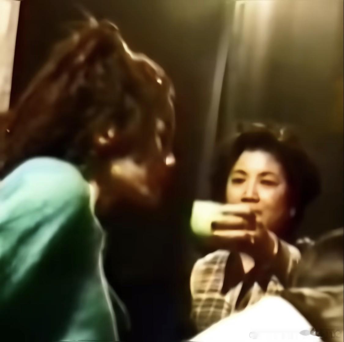这是1994年，王菲香港红磡演唱会后台，母亲夏桂影为女儿喝水。（图一）此时夏桂影