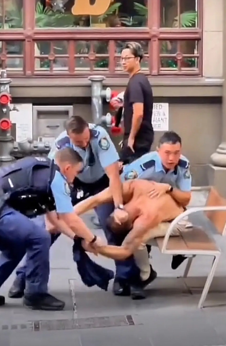美国警察当街执法，一群人压着一个人，阵势比较大。关键有一个奇怪的现象是，