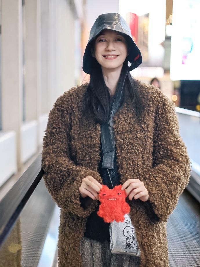 今天倪虹洁现身北京机场，她这回搭配的很有高贵气质，看起来也特别的显年轻。倪虹