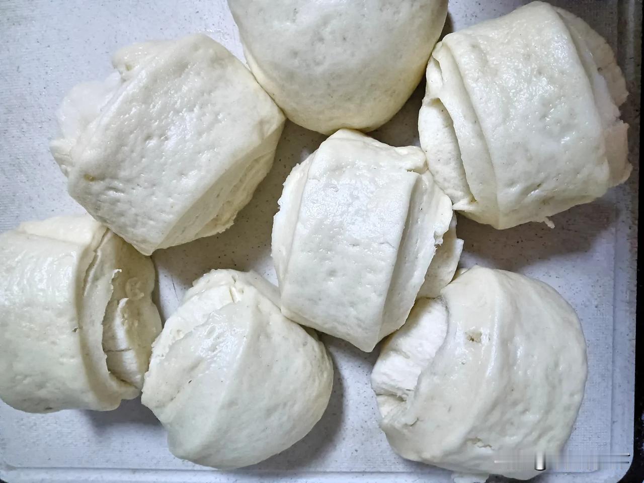 我蒸的手工馒头刚出锅的手工馒头，一个个蓬松暄软，在案板上堆叠出温暖的弧度。