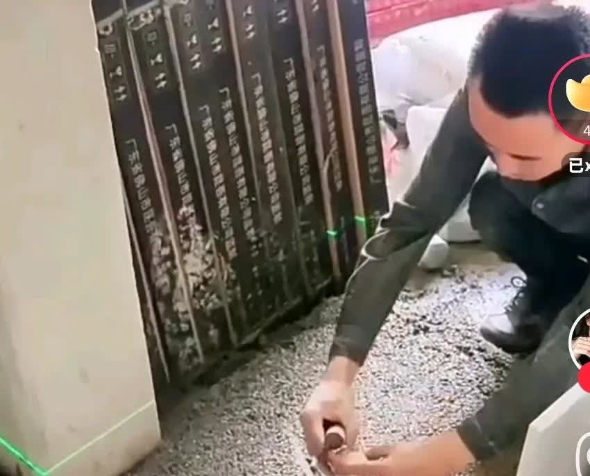 一男子在贴瓷砖的时候，在自己的兜里拿出一个鸡蛋，熟练的打开，把鸡蛋打在水