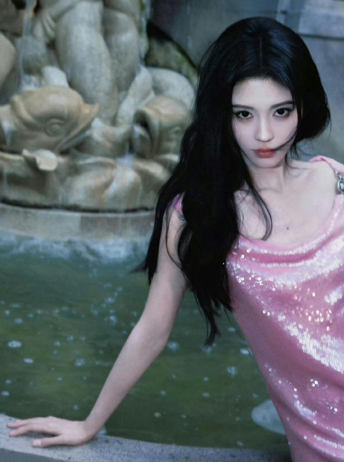 鞠婧祎喷泉的水纹漫过石沿像一整池被揉碎的星她坐在冷硬的边缘粉色亮片裙，是