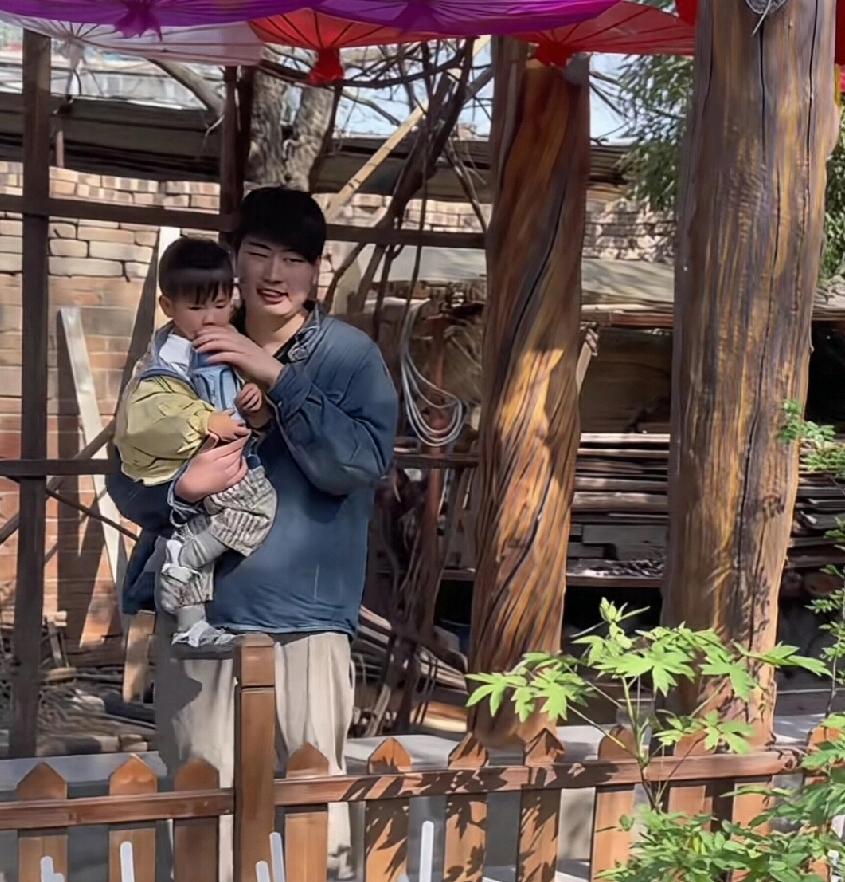 大衣哥的儿子小伟抱着自己的孩子，感觉真的挺像一个大人样的。怪不得人家都说，男