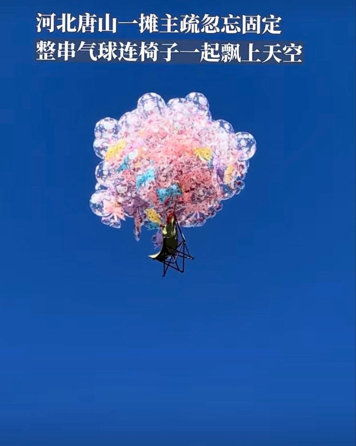 近日，河北唐山一卖气球的摊主，把一大把气球绑在椅子上，疏忽忘了固定，没想到一不留