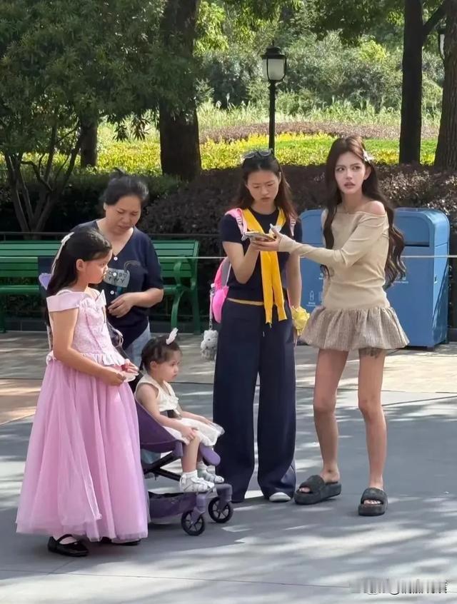 网红韩安冉带小猪妹和优米去上海迪士尼，随行有助理和保姆。路人镜头里她短裙拖鞋，肤