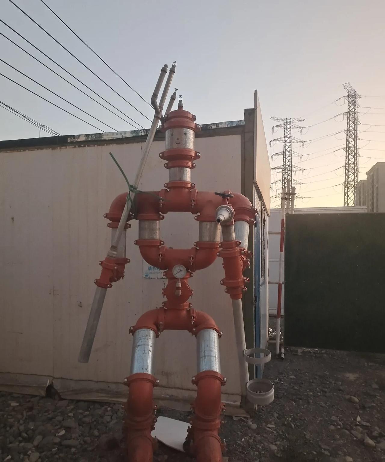 在乌鲁木齐市宁波街北侧一小区建筑工地的围档里，看到了一个用铁管子做成的“机器人”