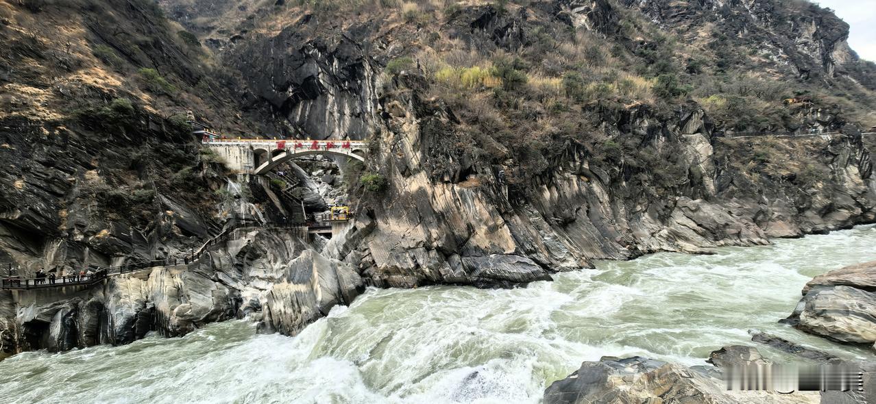 鹧鸪天·虎跳峡万仞崖开一线天，金江怒涌走雷霆。巨石横截千堆雪，虎啸曾惊万里