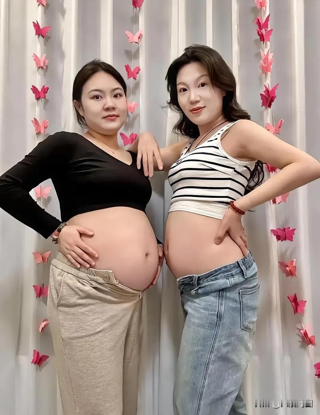 两位准妈妈开心地展示孕肚。