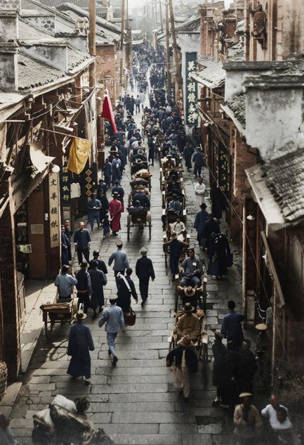 这张照片拍摄于上世纪20年代，是武汉武昌的一条繁华商业主干道街景。街道狭窄而热闹