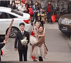 本来应该是新郎抱着上来回家的，喜婆婆高兴地抱着儿媳妇就上来了。从喜婆婆满脸的笑