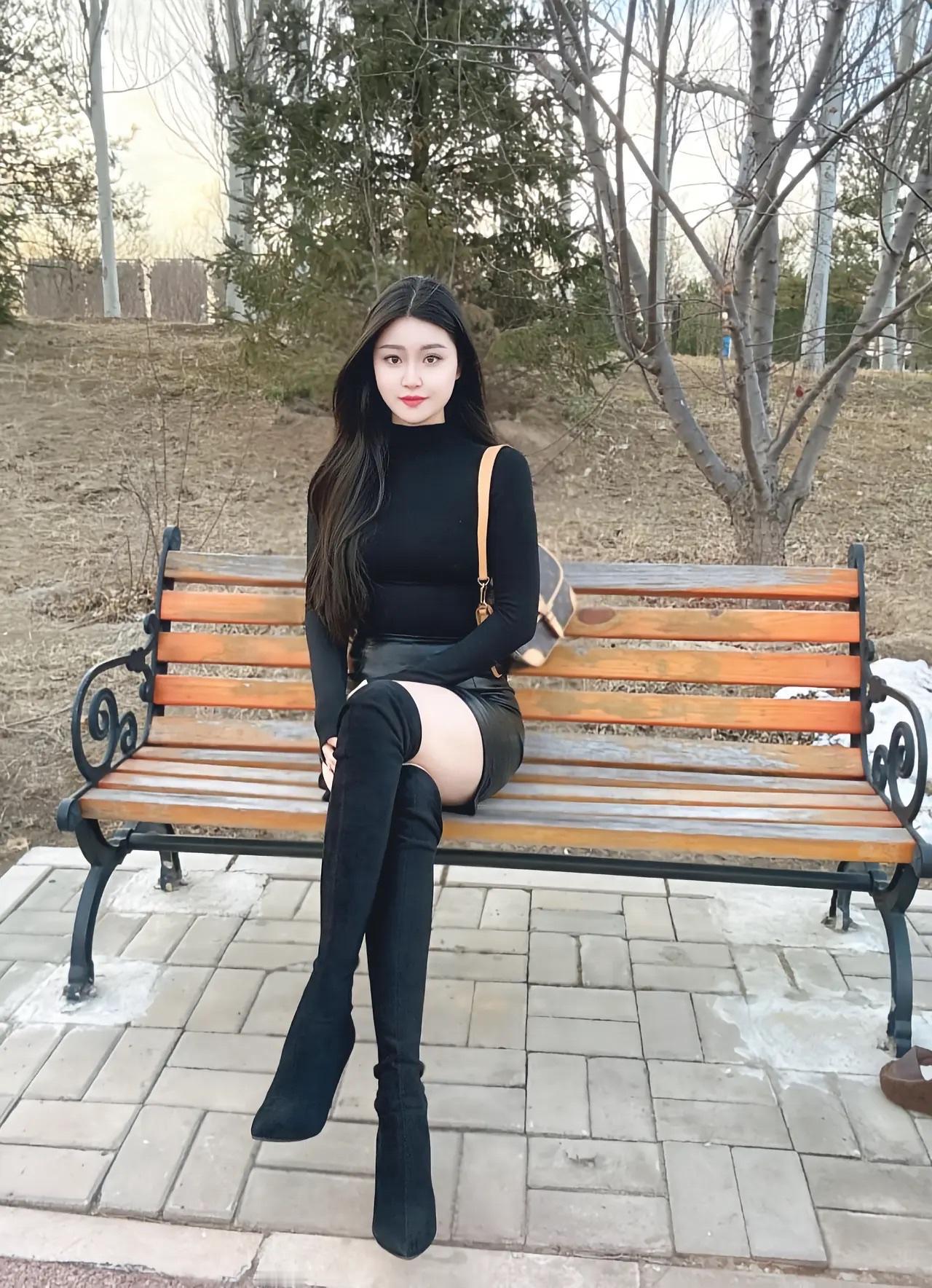 冬日暖阳下，黑裙红唇的优雅女孩，坐在公园长椅上，享受宁静时光。