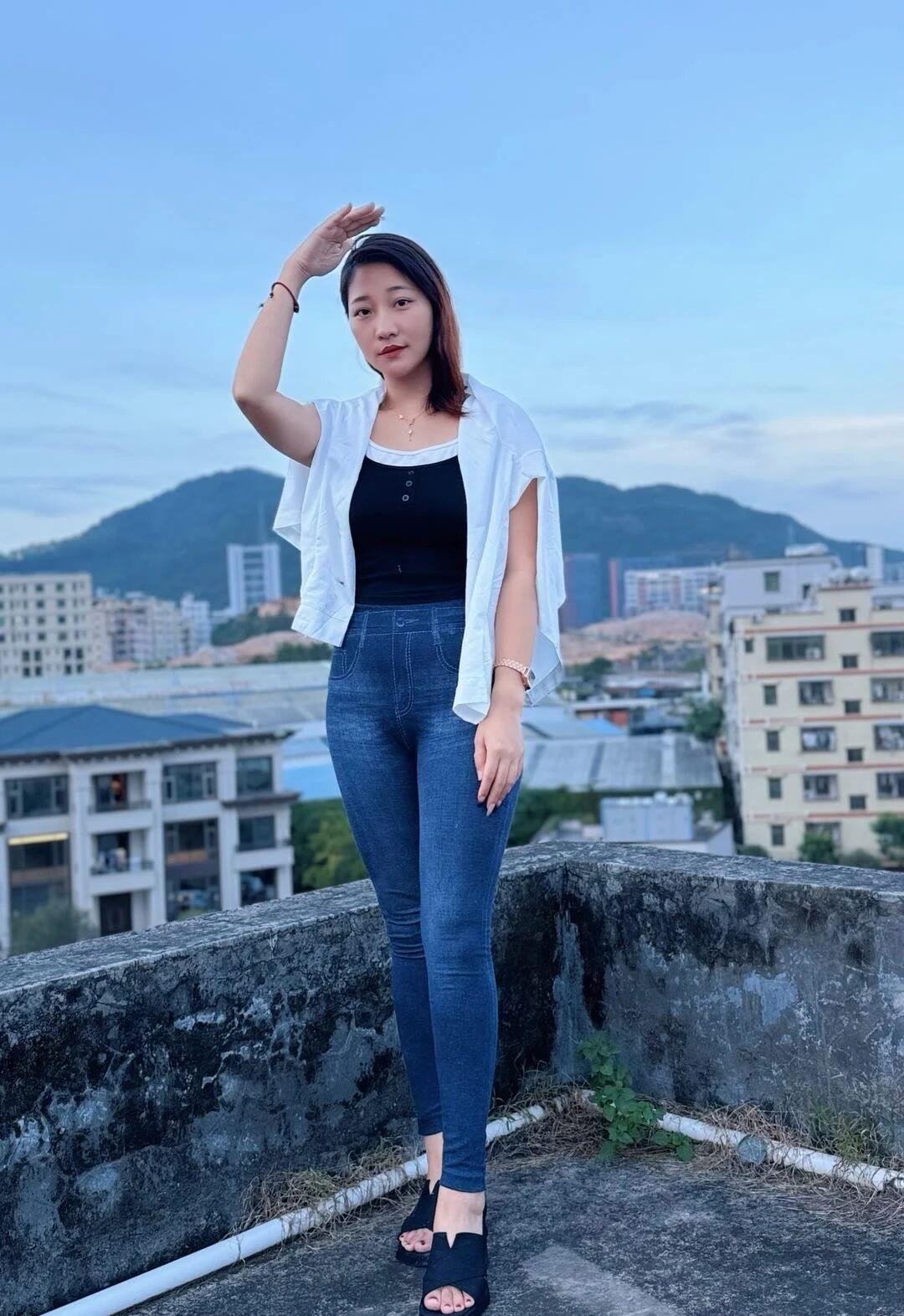 这位女士在屋顶上自拍，风景很美。