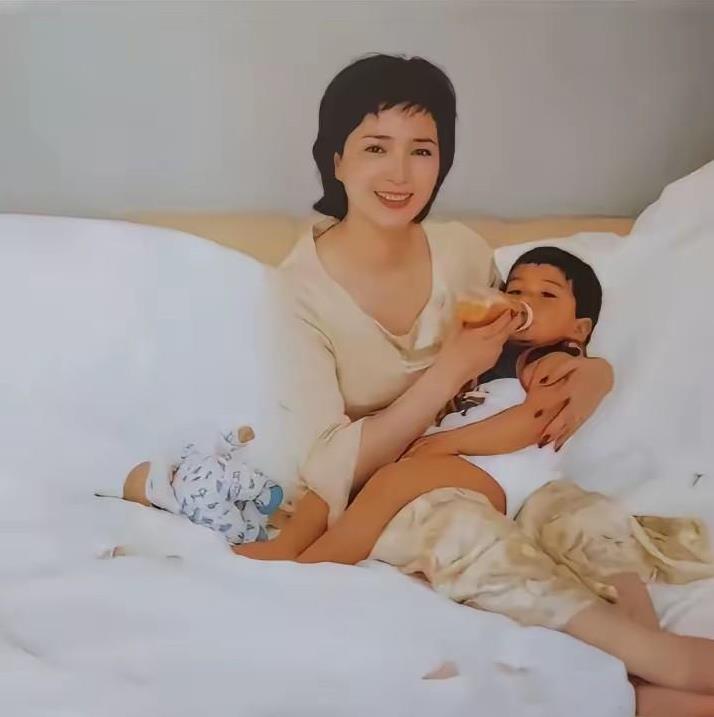 这是2001年，何晴与儿子许何的合影照。成为母亲的何晴脸上透露着幸福的笑容，胖