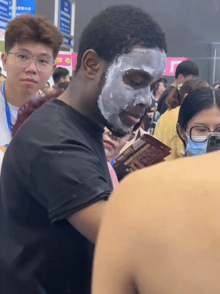这个小黑哥也太好忽悠了吧！一名黑人小哥在街头看见有人摆摊卖美白护肤品？于是他