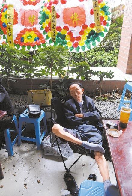 2008年，“笑星”刘德一的灵堂外，庞祖云前来送别老友，连日守灵过度疲惫，坐在折