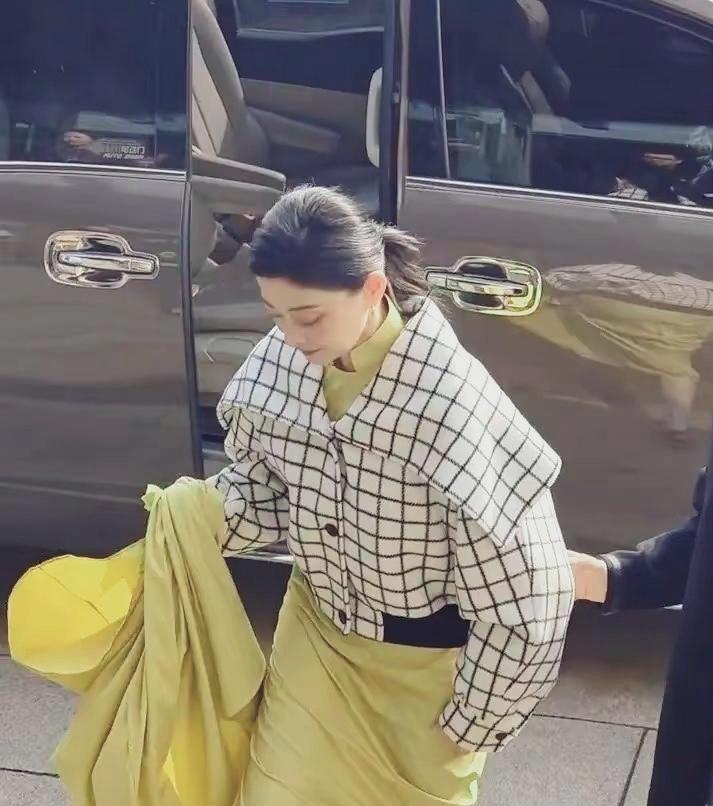50岁梅婷身穿黄色礼服,外搭黑白格大翻领上衣,皮肤白皙,黑眼圈不明显!皮肤略有松