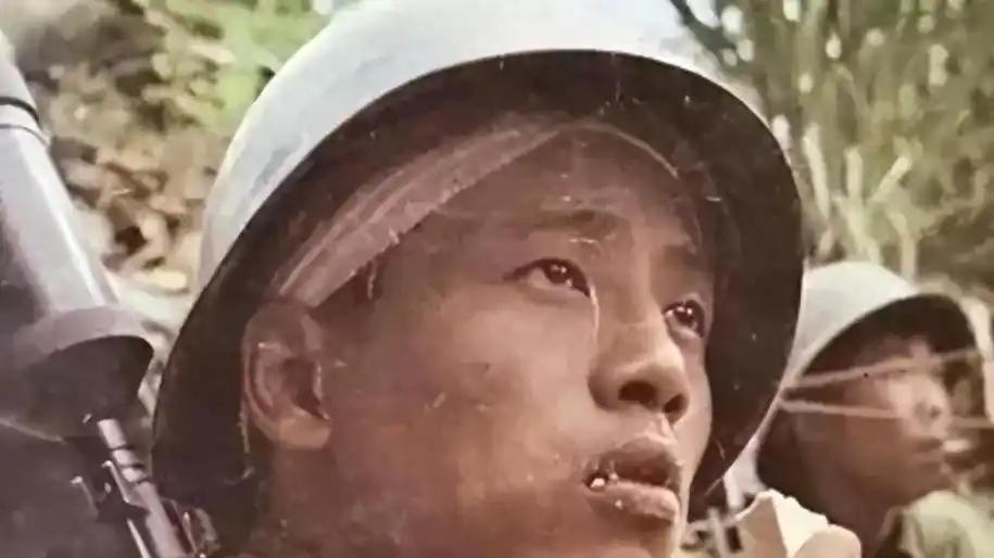 1987年4月20日，在老山战役，越军手持喷火器，喷向我方弹药库，一名嘴啃压缩饼