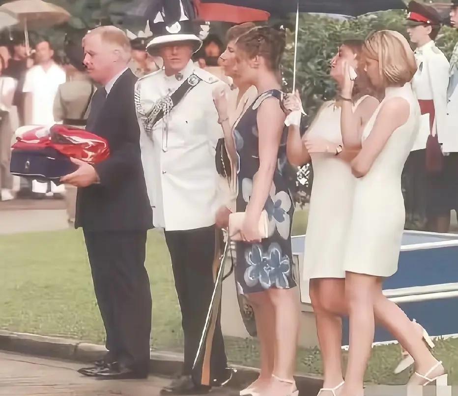 1997年6月30日，末代港督彭定康在降旗仪式上的一幕，镜头中他双手捧着降落下来