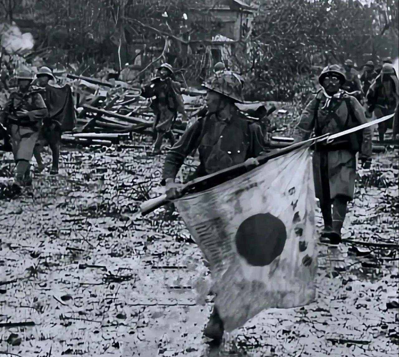 这是记录侵华日军暴行的黑白历史照片。画面中，头戴钢盔的日军在被战火摧毁的中国城镇
