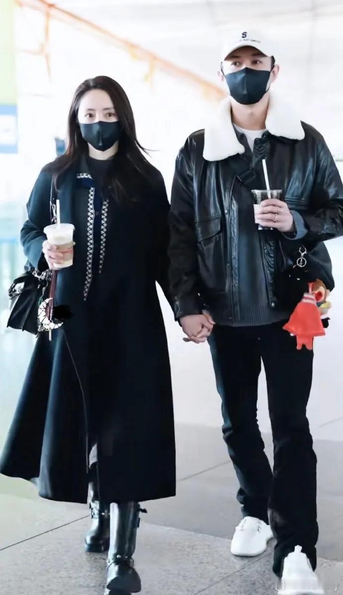 今天董璇和张维伊手牵手亮相机场，两位都穿了黑色的衣服，看起来格外的般配。