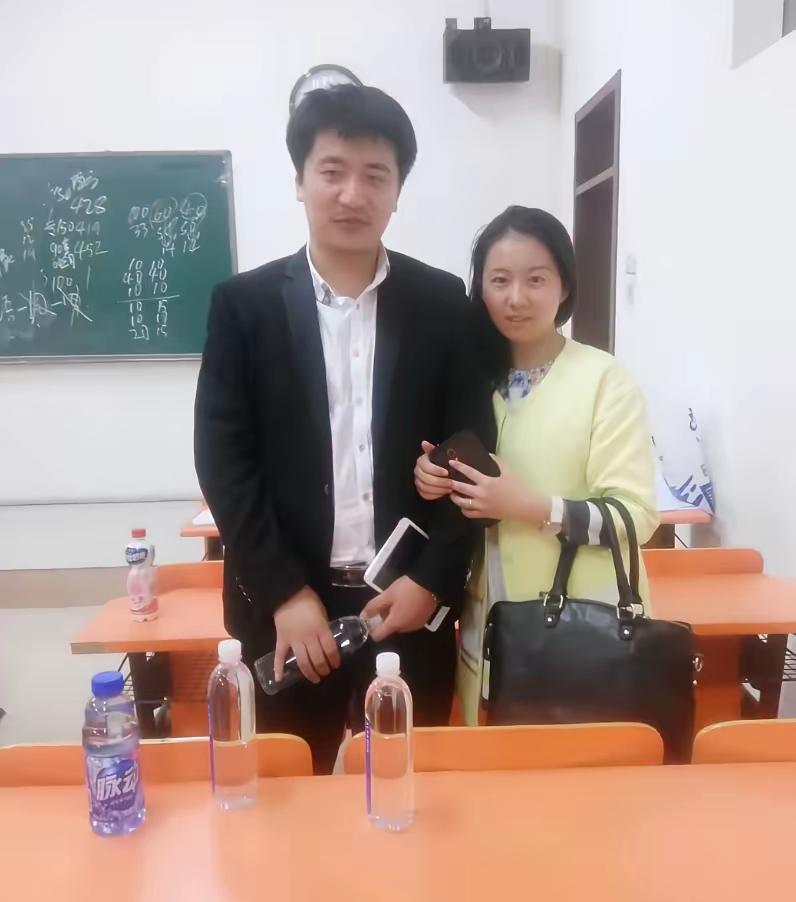 李丽倩与张老师的一张合影。背景是在教室的培训班里，那时候他们在北京创业。张老师看