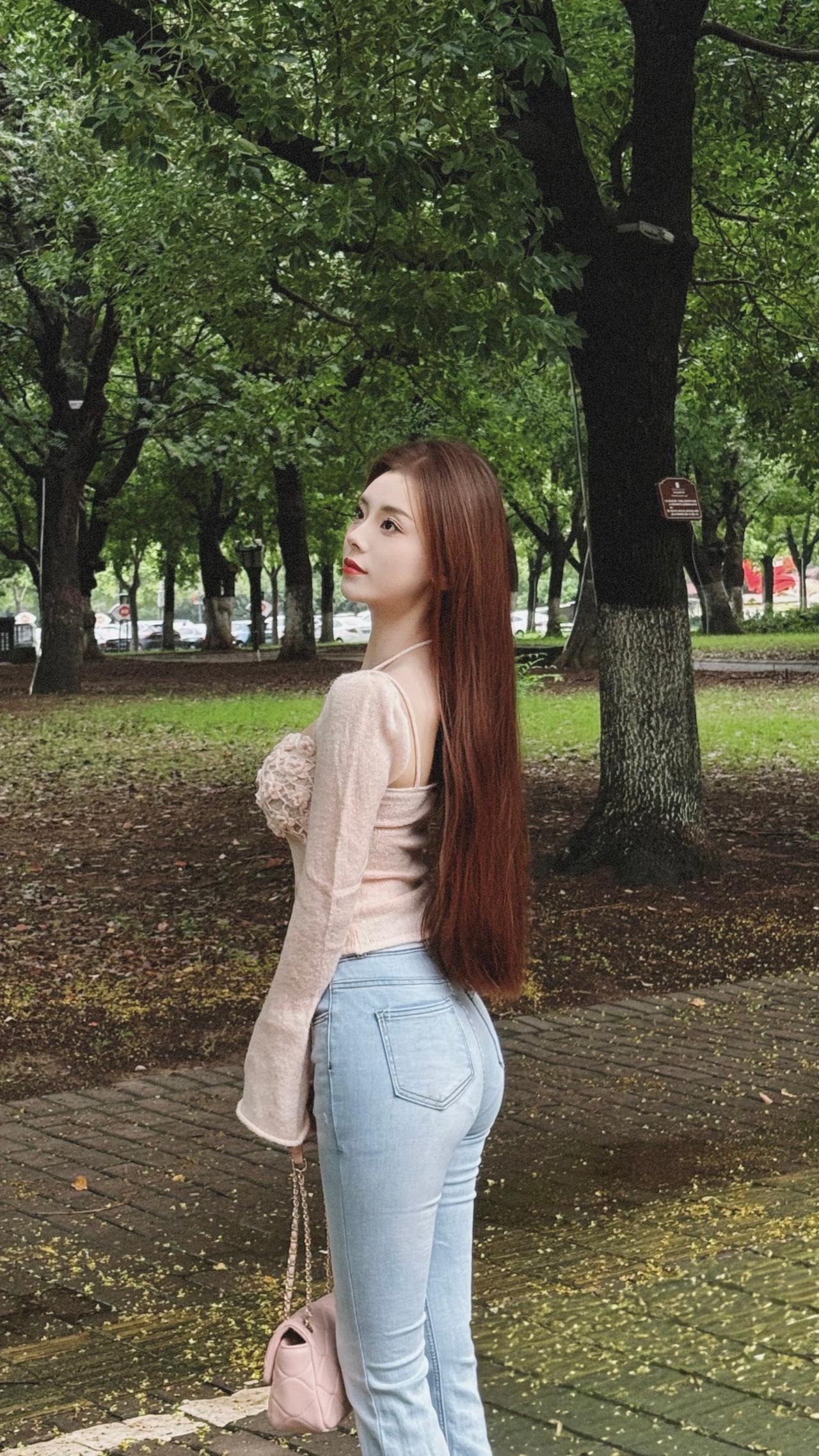 绿意中的灵动芳华漫步于葱郁的林间小道，她宛如自然书写的诗意篇章。那一头如绸缎般