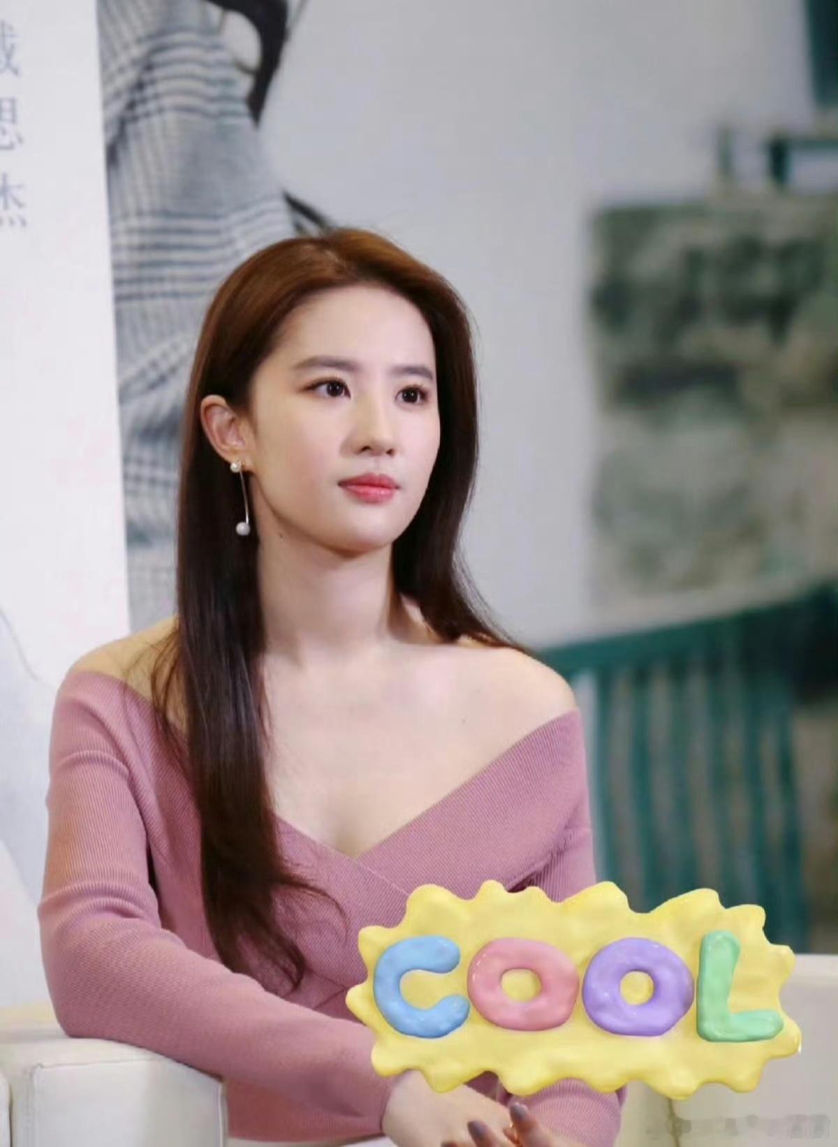 刘亦菲这次选择了一身极简风格的温柔穿搭，豆沙粉一字肩交叉V领针织上衣，软糯细腻的