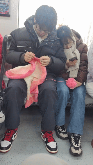 地铁上看到一男生正在帮他的女朋友织毛衣？而他的女朋友则倚靠在男生的肩膀上玩手机
