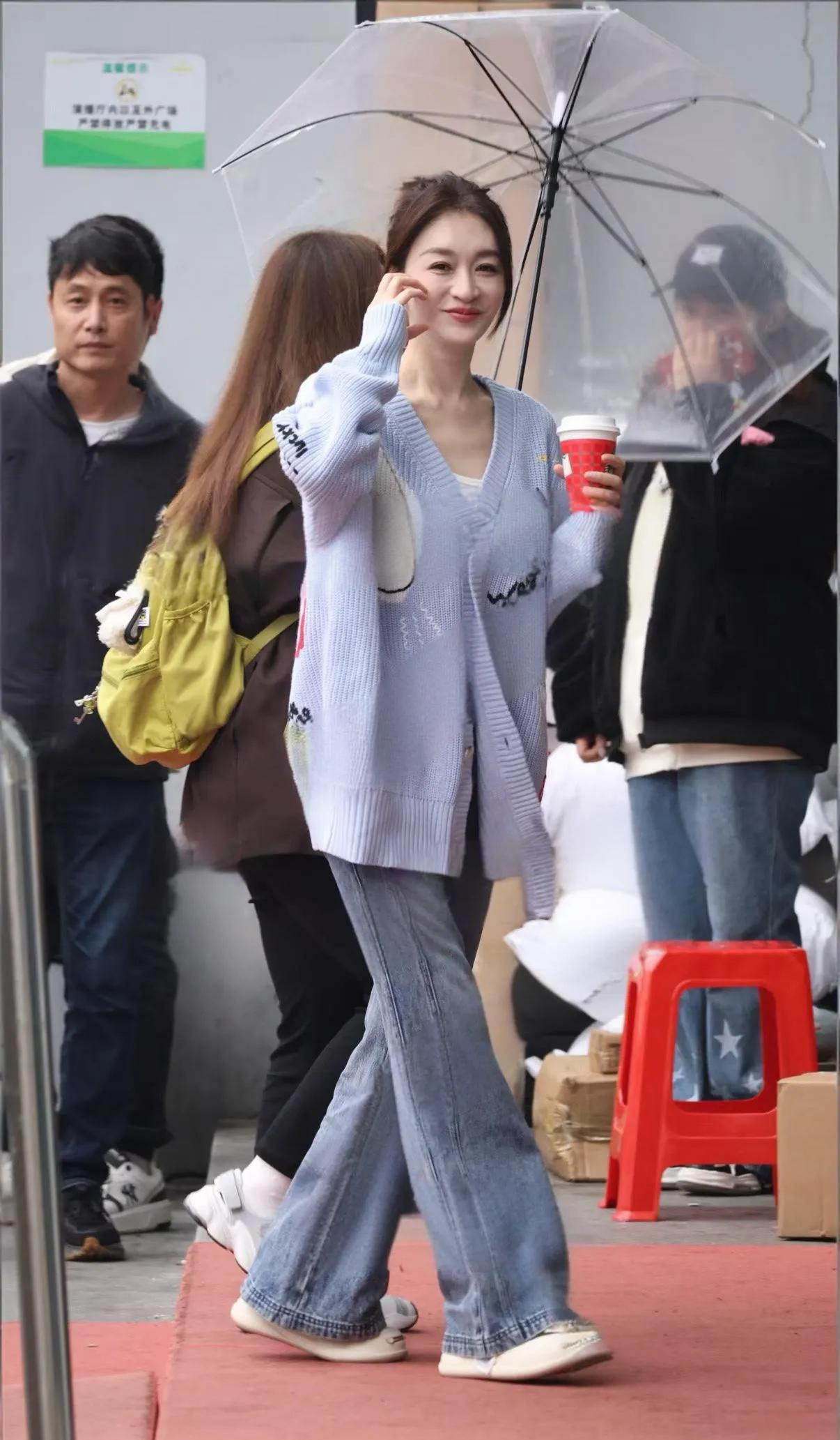 50岁的李小冉‌在湖南长沙一家便利店被路人偶遇，她身穿浅蓝色大V领针织衫搭配牛仔