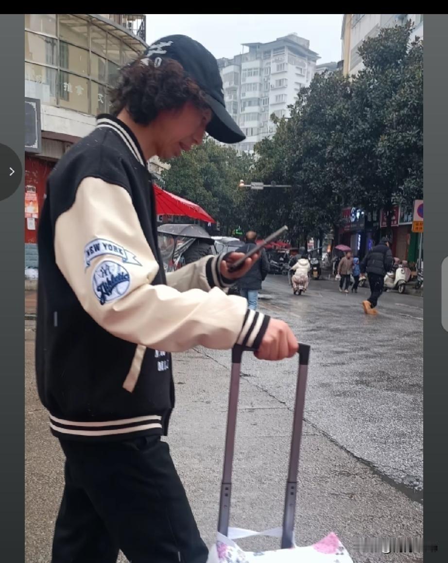 偶遇国际巨星庞麦郎。他拉着行李箱，戴黑色帽子，穿一身黑色衣裤。没保镖开道，就这么