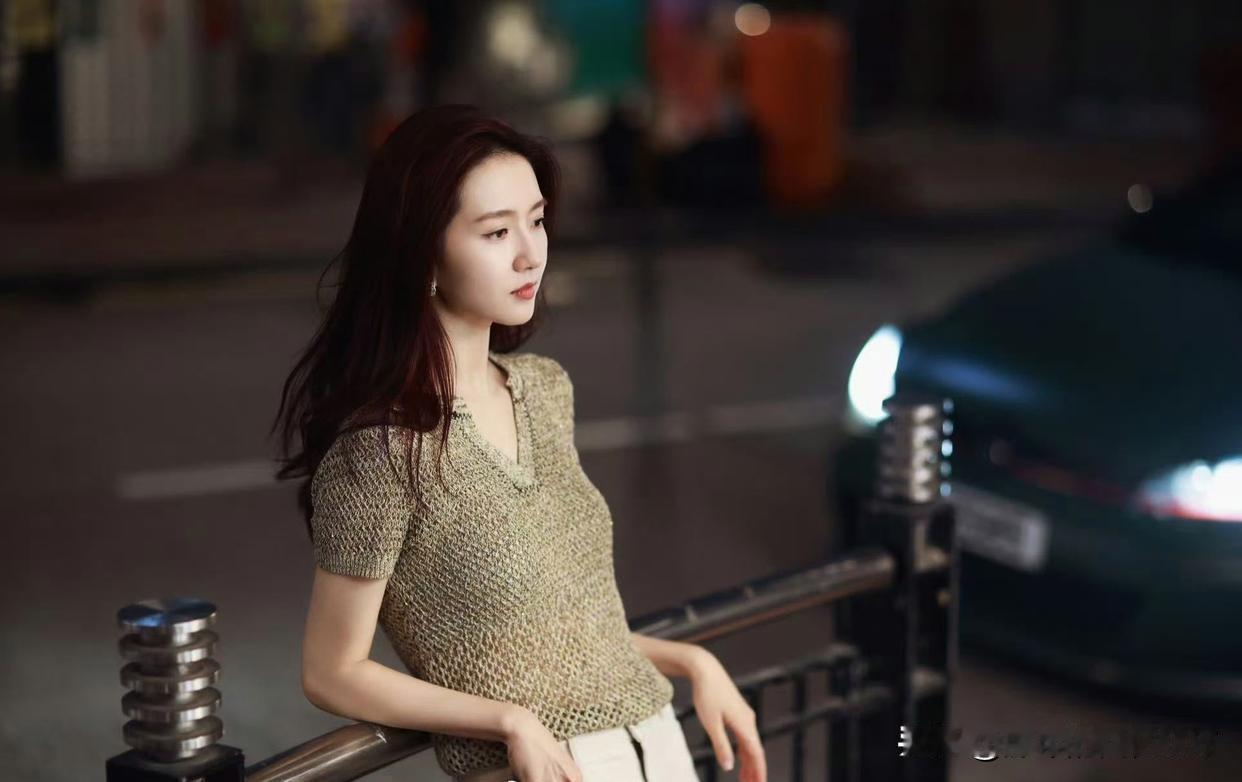 怎样穿搭能显示出温柔的女生气质?都市夜景下的优雅女子，红唇轻启，夜色迷人。