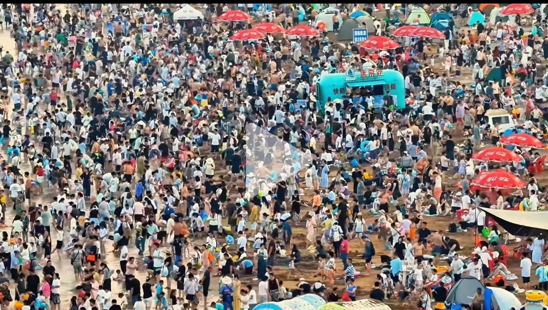 青岛各海水浴场开启万人共浴下“饺子"的模式，游客们在大海里避暑
