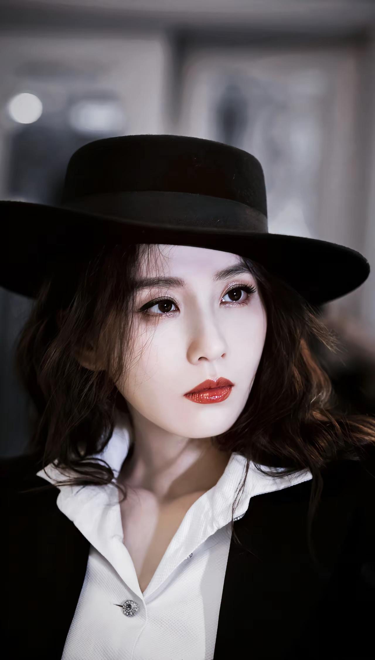 刘诗诗，宽檐礼帽掩住流转的眸光，黑白碰撞勾勒出复古轮廓发丝慵懒垂落，红唇衬出明