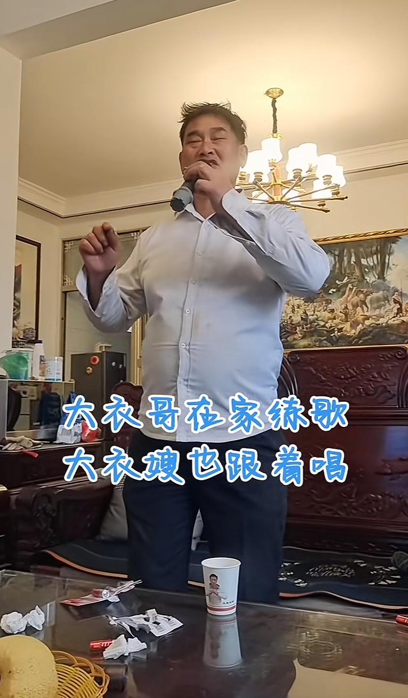 大衣哥又在家练歌，拿着话筒唱《女儿情》，确实唱的特动情，老婆也不由得跟着唱起来。