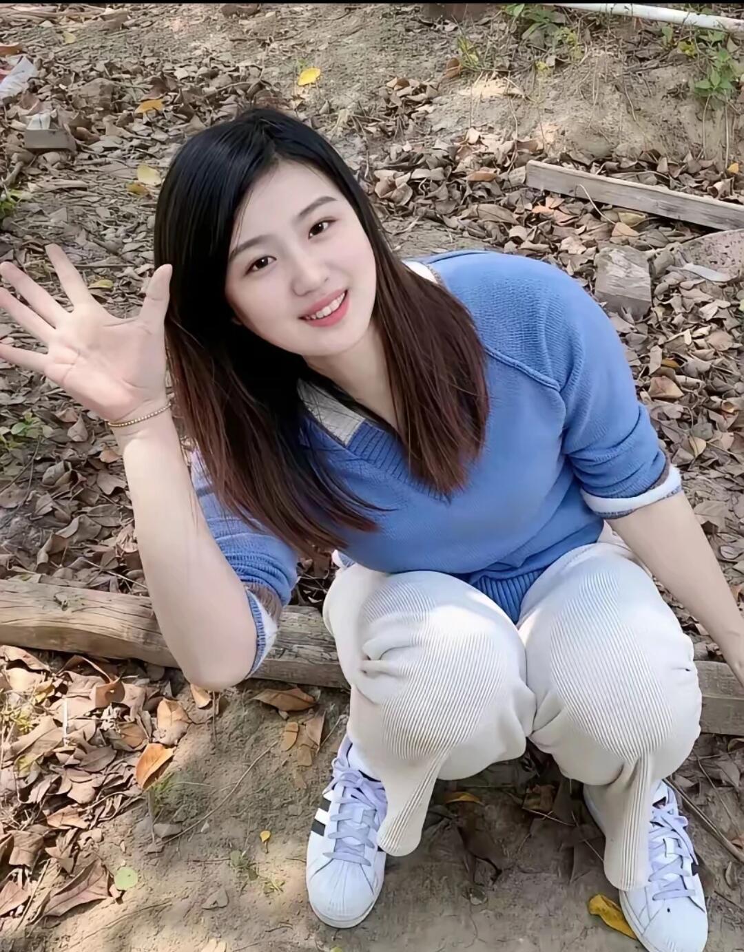 田间少女落叶堆中藏俏影，蓝衫素裤衬娇容。蹲身笑对三春景，伸手轻迎一晌风。简