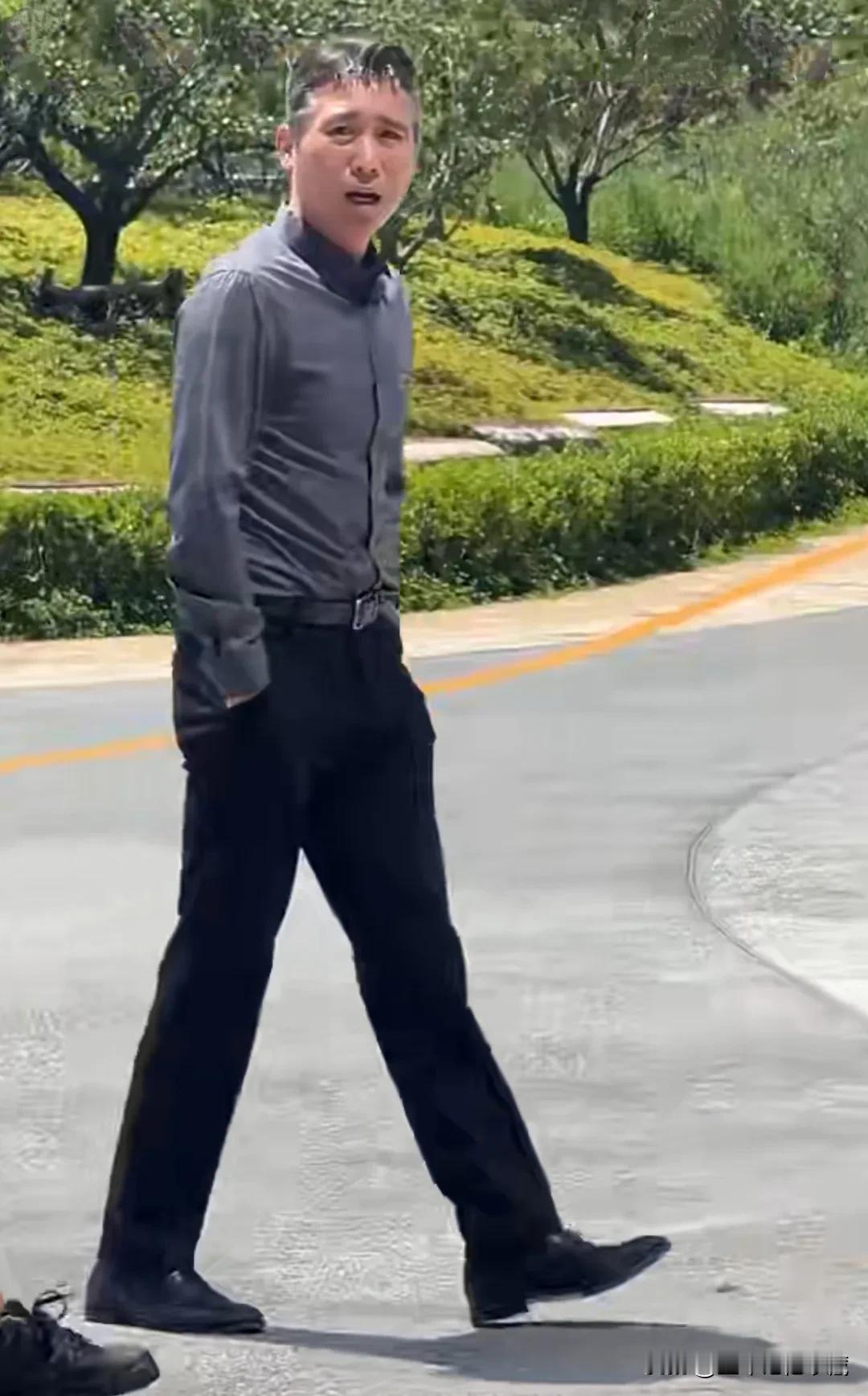 型男李乃文被粉丝偶遇，一件灰色修身长袖衬衫，黑色长裤，搭配黑色正装皮鞋，李乃文显