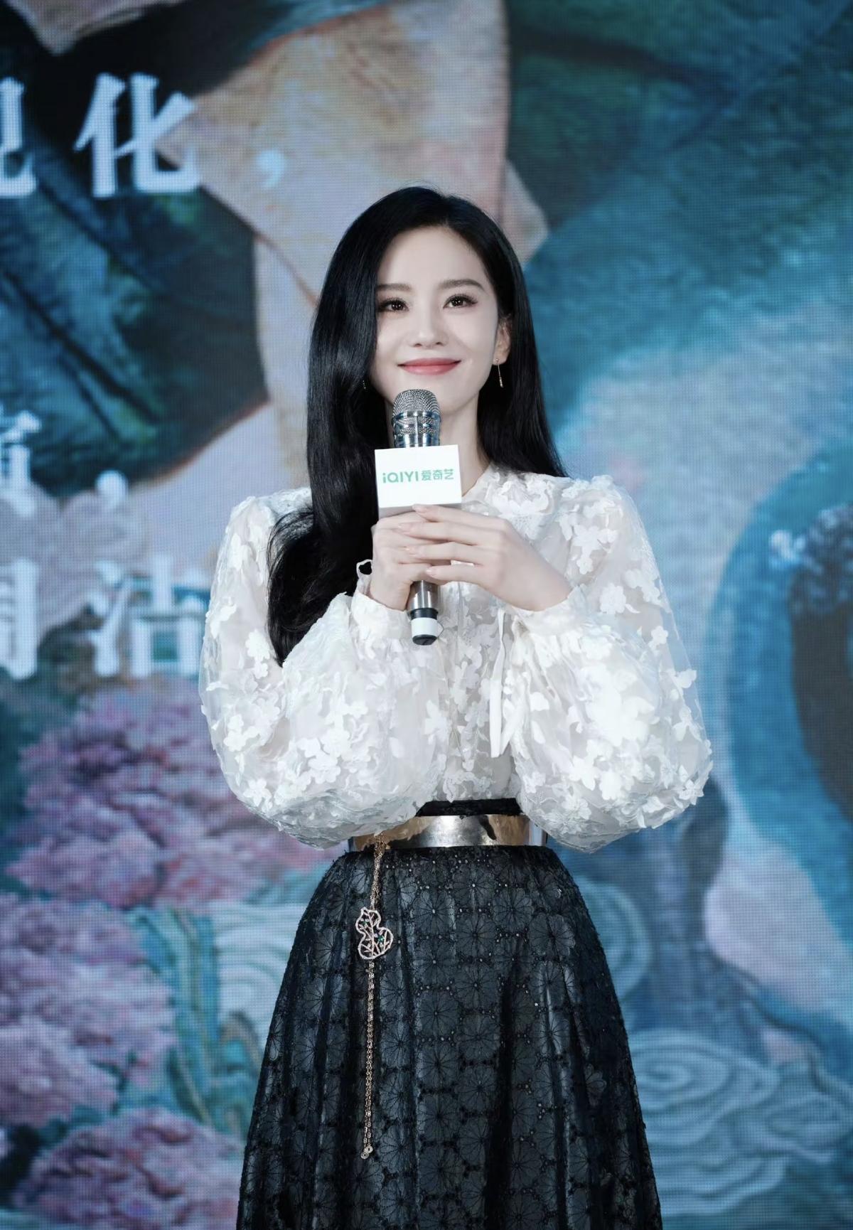刘诗诗白花朵泡泡袖上衣搭配暗纹黑色半裙，金属腰封勾勒腰线，葫芦配饰点缀细节，黑长