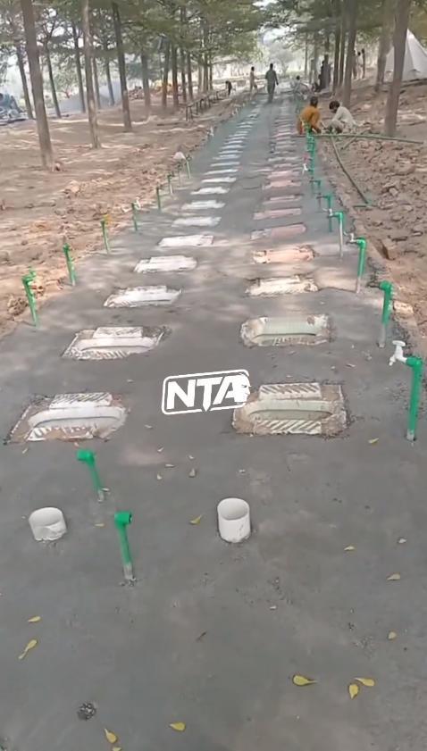 视频中印度一座公园里正在建设的公共厕所地基呈队列状排列，从远处看，颇具讽刺意味地