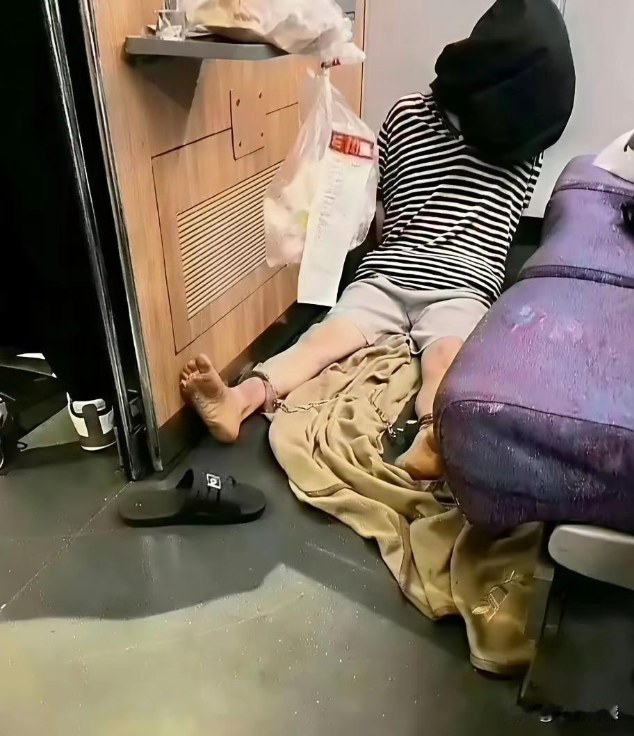 坐在地上的这个人，脚踝上好像是有东西，细细分辨，像是铁链，这个人应该是有问题，感